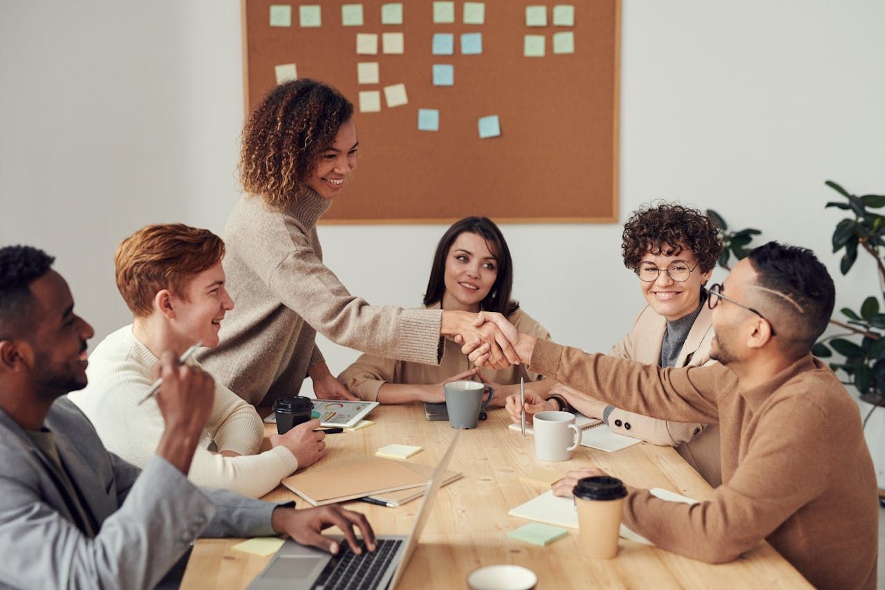 Un grupo de personas diversas llegan a un acuerdo en su oficina.